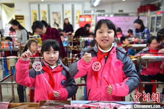 圖為小學(xué)生展示繡制好的2022年北京冬奧會(huì)吉祥物“冰墩墩”形象?！∮髟屏?攝