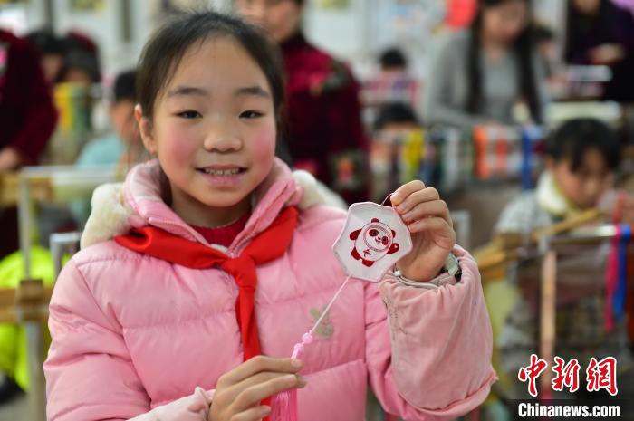 圖為一名小學(xué)生繡制的2022年北京冬奧會(huì)吉祥物“冰墩墩”形象。　喻云亮 攝