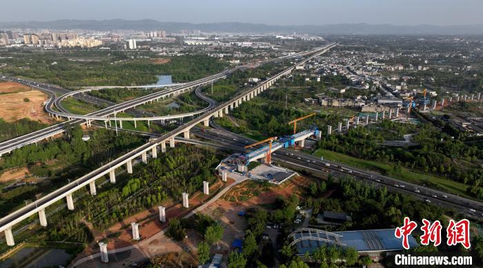 航拍正在建設(shè)的跨越成都繞城高速公路連續(xù)梁施工現(xiàn)場，旁邊依次為已運營的成渝高速鐵路和機場高速公路。　劉忠俊 攝