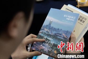 參展觀眾閱讀浙江文旅手冊(cè)?！《≌裾?攝