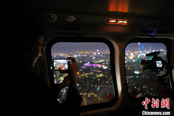 6月3日晚，游客乘坐上海新空直升機有限公司直升機開啟鳥瞰黃浦江空中圓夢之旅，并用手機拍攝城市夜景?！∫罅⑶?攝