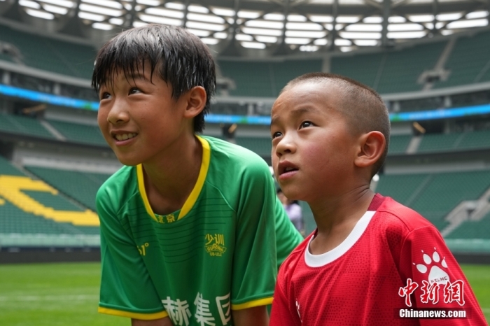 圖為北京國(guó)安小球員陳小北和7歲的俄金仁增在一起觀看場(chǎng)內(nèi)播放的紀(jì)錄片。<a target='_blank' href='/' _fcksavedurl='/'><p  align=