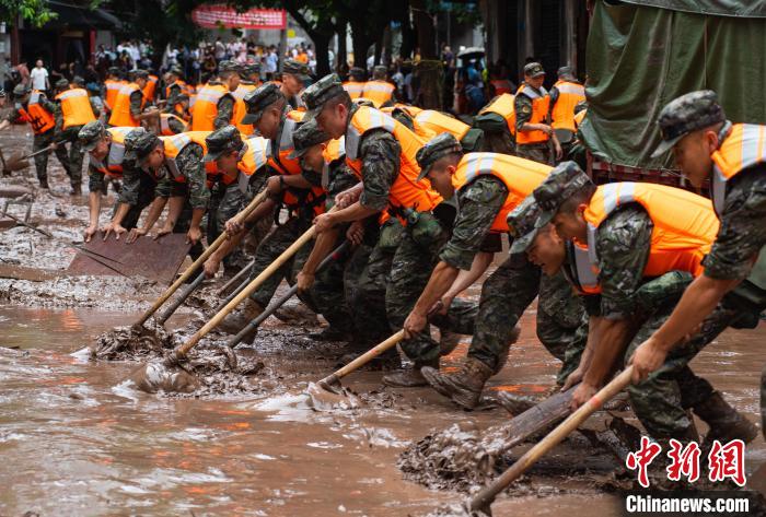 7月4日，萬(wàn)州區(qū)五橋街道，武警官兵清理街道上的淤泥?！∪矫宪?攝