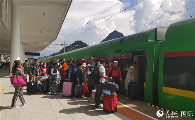 乘坐中老鐵路國際旅客列車的旅客在老撾瑯勃拉邦站排隊(duì)上車。人民網(wǎng)記者 杜明明攝