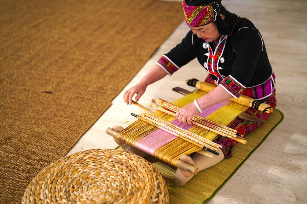 4月17日，黎族傳統(tǒng)紡染織繡技藝國(guó)家級(jí)代表性傳承人劉香蘭在2023年意大利米蘭設(shè)計(jì)周上展示黎錦織造技藝。新華社發(fā)