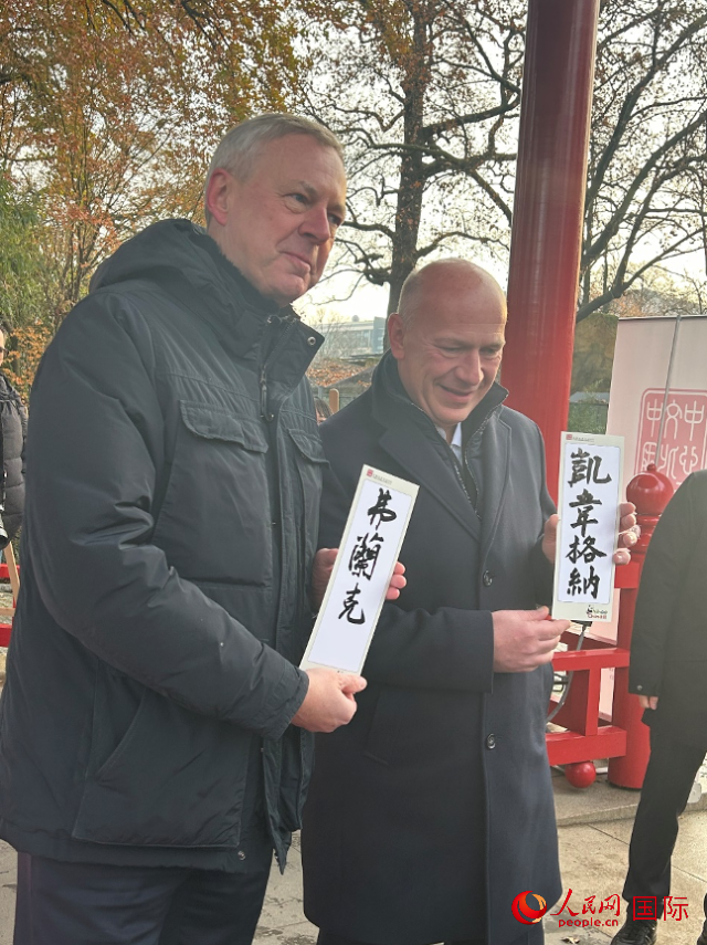 柏林市長韋格納（右）、動(dòng)物園監(jiān)事會(huì)主席布魯克曼（左）手持中國文化中心工作人員現(xiàn)場手書的中文名字。人民網(wǎng)記者 徐馨攝