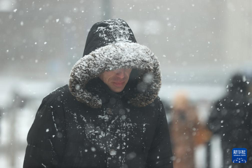1月17日，在比利時布魯塞爾，人們冒雪出行。新華社記者 趙丁喆 攝
