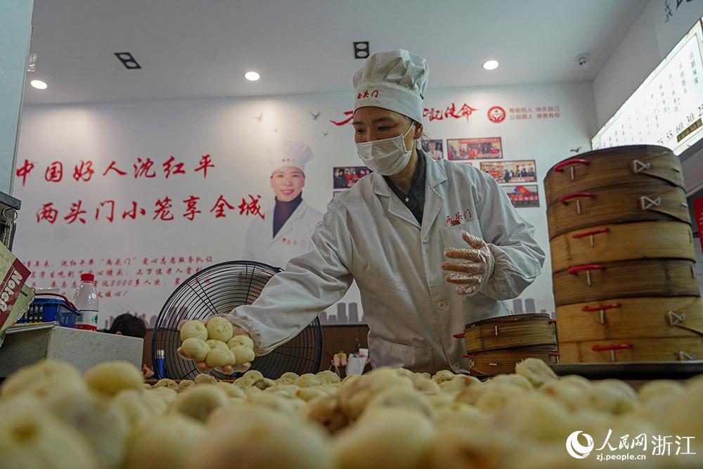 3月31日，在浙江省嵊州市甘霖鎮(zhèn)，嵊州小吃從業(yè)者沈紅平把蒸熟的小籠包晾涼，打包冷藏售賣。人民網(wǎng) 章勇濤攝