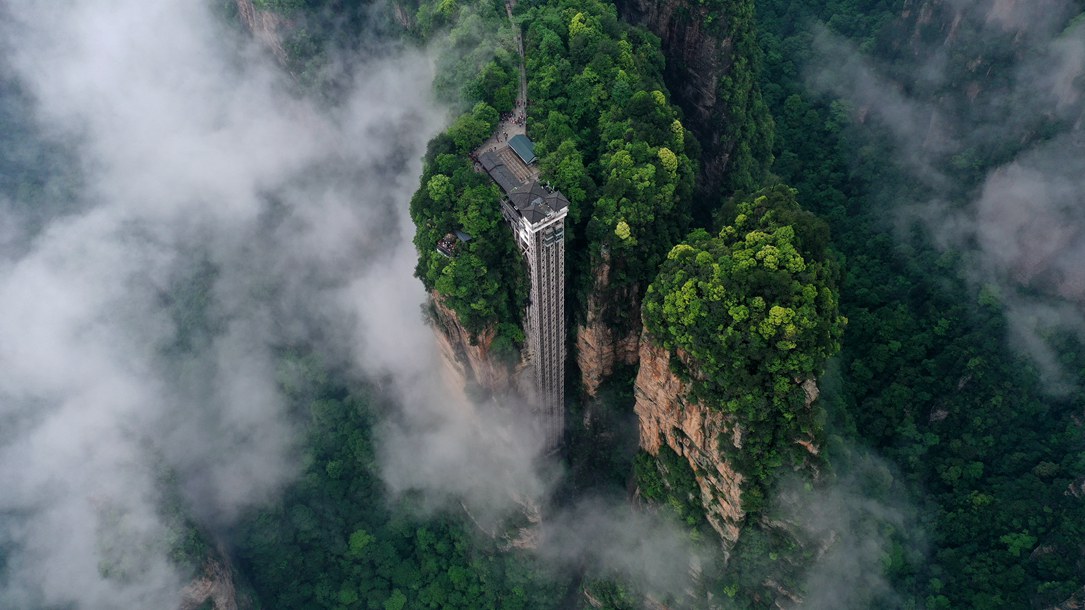 位于張家界武陵源景區(qū)的百龍?zhí)焯蓁偳对谠旗F繚繞的峰林間，雄偉壯觀。吳勇兵攝