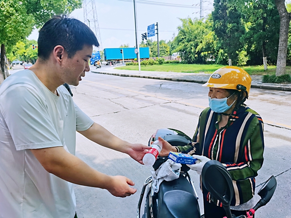 何超為過路的老人送上礦泉水和冷飲。人民網(wǎng)記者 王繼亮攝