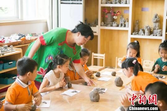 圖為劉雪玲正在給幼教中心的孩子上泥塑課。　鐘欣 攝