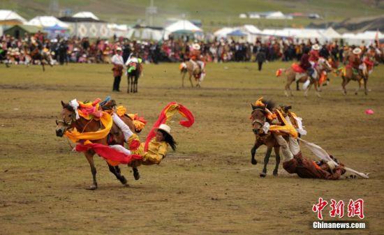 8月4日，四川理塘“八一”賽馬場(chǎng)上演一場(chǎng)精彩的馬術(shù)競(jìng)技比賽，引來(lái)上萬(wàn)民眾和游客觀賽。圖為牧民騎手進(jìn)行五彩凌空競(jìng)技。 中新社記者 劉忠俊 攝