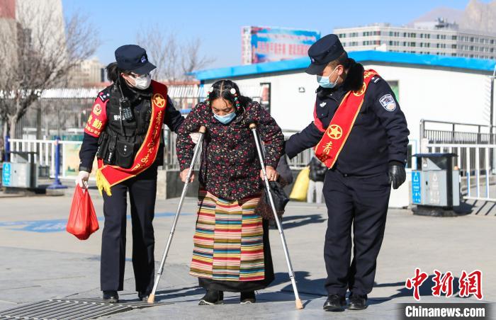 圖為拉薩鐵路公安民警幫助老人進站乘車。　胡安鵬 攝