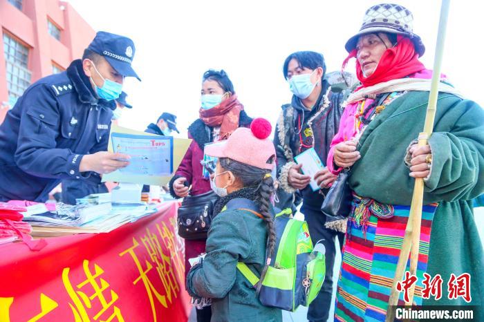 圖為拉薩鐵路公安民警向旅客發(fā)放乘車安全宣傳資料?！↑S飛 攝