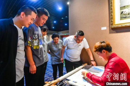 圖為南京市民觀賞湟源縣非遺產(chǎn)品制作?！′以纯h委宣傳部 供圖