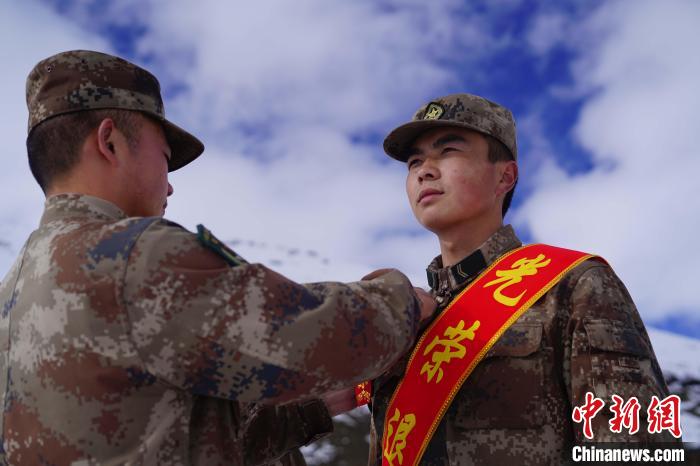 排長王朝偉(圖左)給退伍老兵佩戴大紅花?！∥鞑厣侥宪姺謪^(qū)某團(tuán)供圖