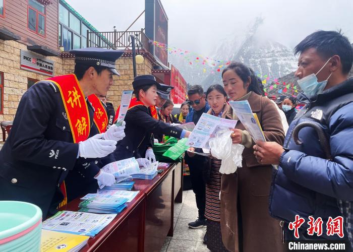 圖為山南玉麥邊境派出所民警為轄區(qū)群眾發(fā)放法律知識(shí)宣傳單?！＄婗?　攝