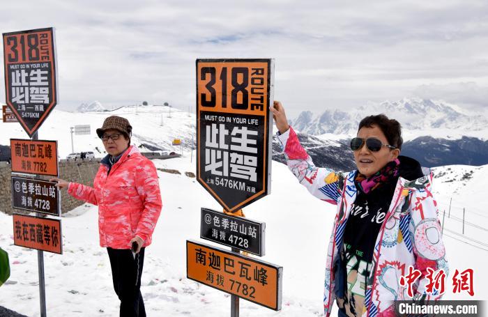 圖為5月14日，西藏林芝色季拉山觀景臺，游客與南迦巴瓦峰合影?！±盍?攝