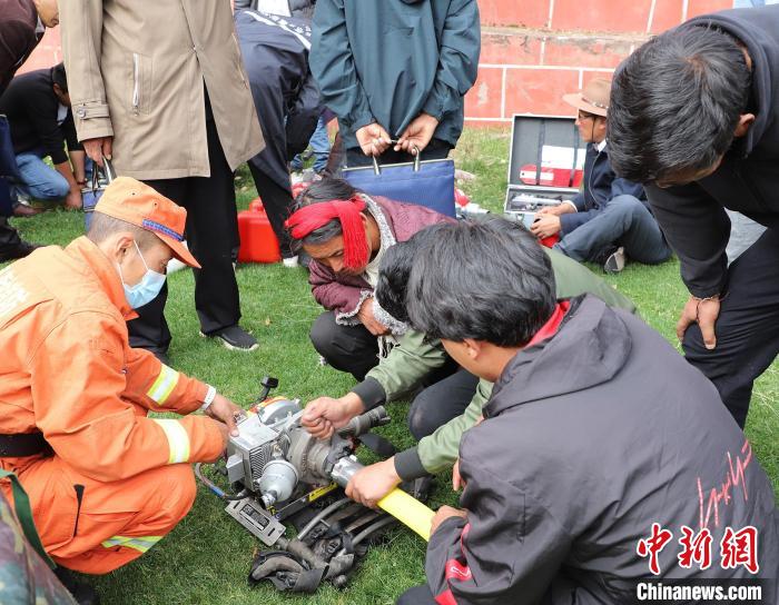 圖為森林消防員為護林員講解滅火裝備的使用方法。　昌都市森林消防支隊 供圖