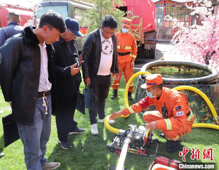 圖為森林消防員為護林員講解滅火裝備的使用方法?！〔际猩窒乐ш?供圖