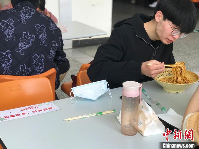 3月17日，西藏大學學生正在學校食堂用餐，餐桌上寫著“按需取餐，切勿浪費”。　冉文娟 攝