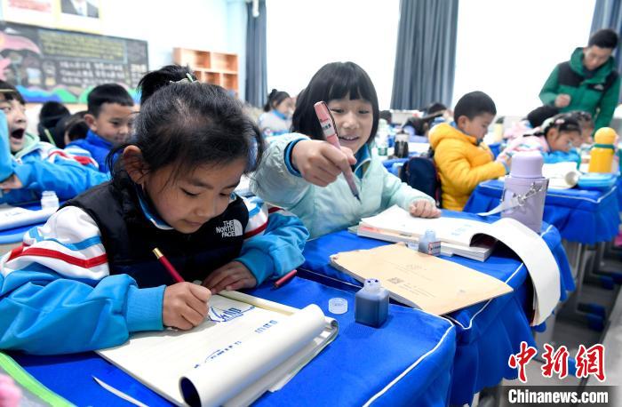 3月14日，西藏拉薩市第一小學一年級六班學生白瑪朗珍(圖左)在藏語文課上書寫藏文?！±盍?攝