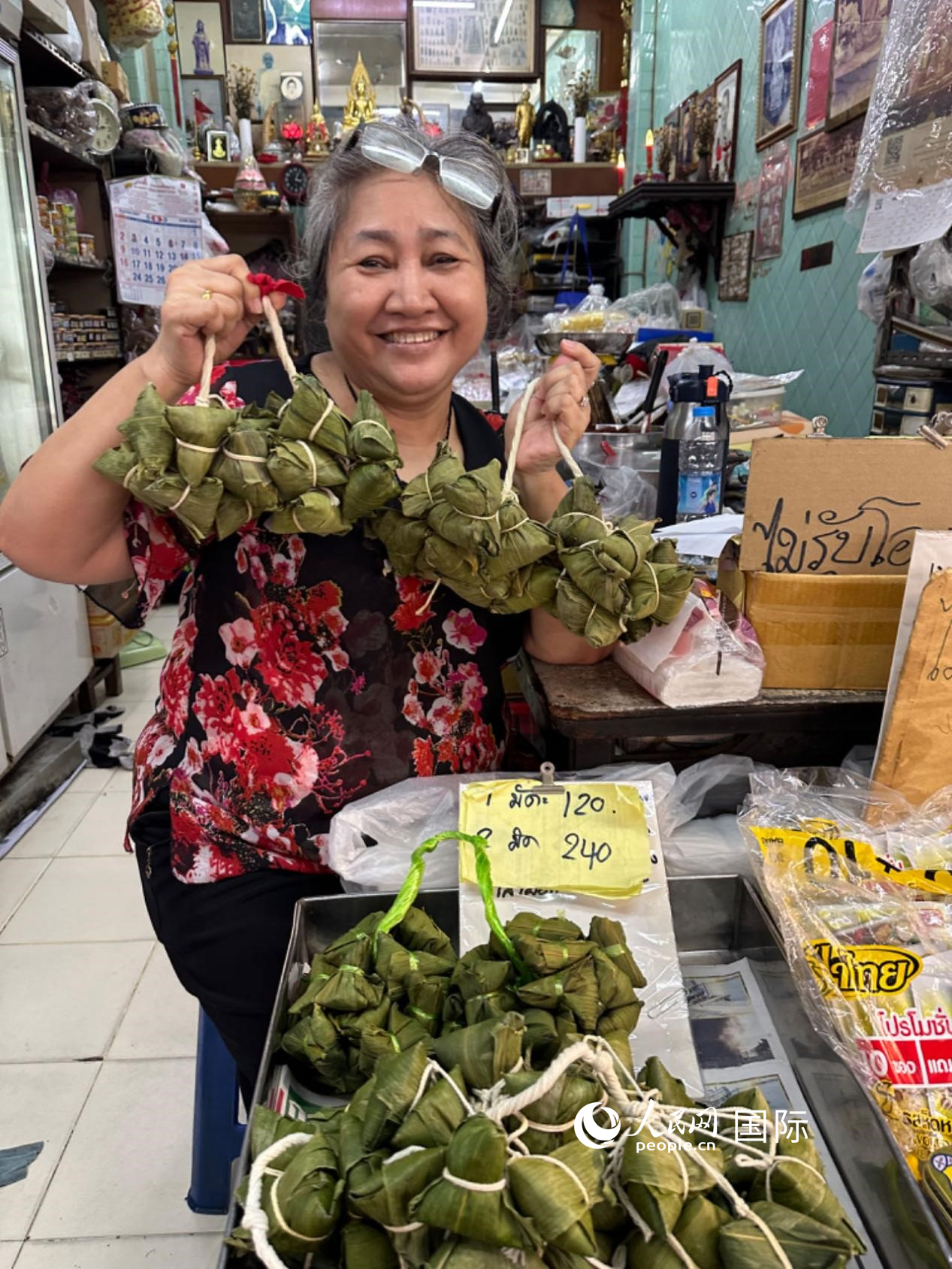 商家向顧客介紹“吉掌”（粽子的一種，一串一串，個(gè)頭較?。Ｈ嗣窬W(wǎng)記者 簡(jiǎn)承淵攝