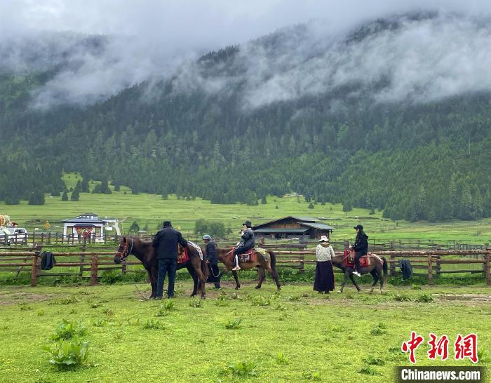 6月10日，游客在魯朗小鎮(zhèn)高山牧場(chǎng)景區(qū)體驗(yàn)騎馬?！∪轿木?攝