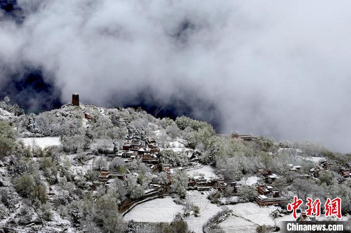 雪后的藏寨和碉樓構(gòu)成美麗的雪景?！〗党鯘衫?攝