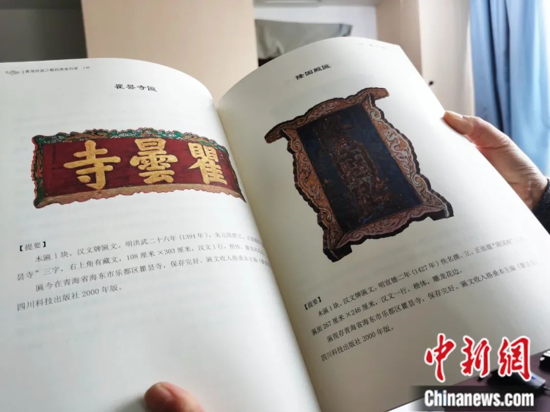 古籍保護(hù)人員展示介紹明代朱元璋撰寫的青海瞿曇寺匾(左)的出版書籍。張?zhí)砀?攝