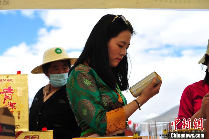 圖為拉薩市民在特色農(nóng)畜產(chǎn)品展示展銷會上選購商品?！垈?攝