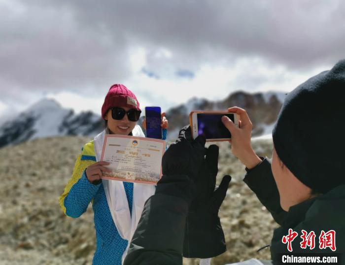 圖為5日，登頂洛堆峰的登山者獲得西藏自治區(qū)登山協(xié)會(huì)頒發(fā)的登頂證明?！垈?攝