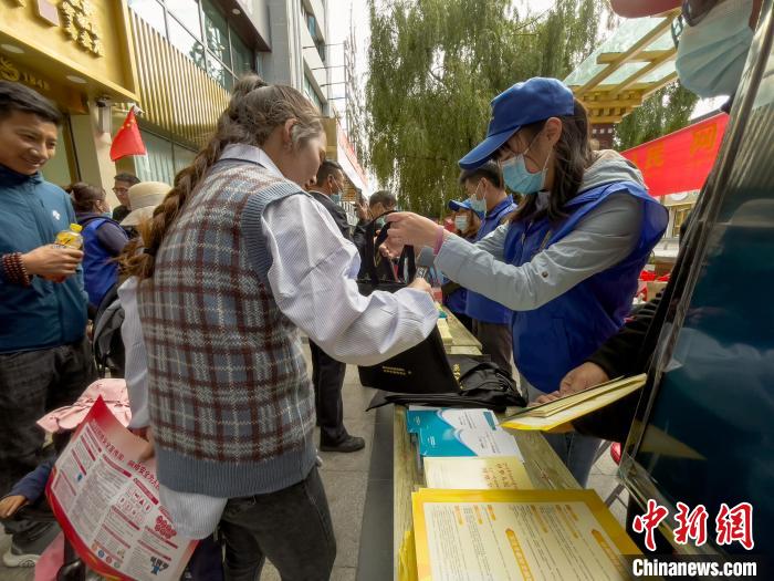 圖為志愿者為市民發(fā)放網(wǎng)絡安全宣傳手冊?！≈x牧 攝