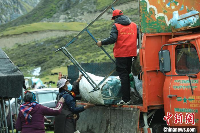 圖為工作人員幫助牧民們卸家具?！÷蹇?攝