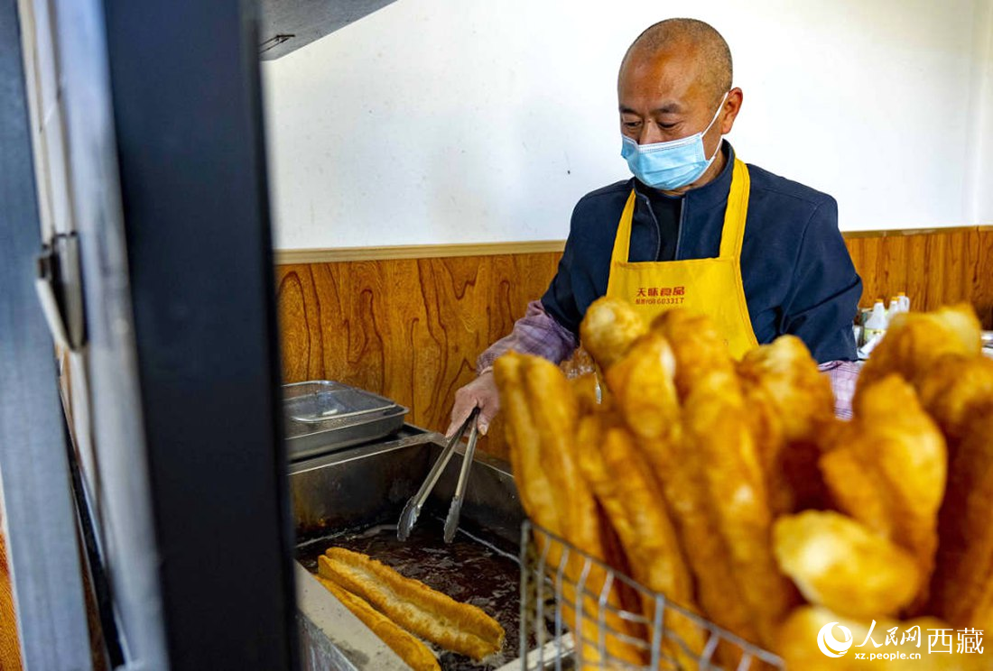 早餐店老板正在炸油條。人民網(wǎng) 次仁羅布攝