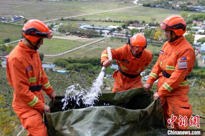 技能大練兵過程中，消防員在陡坡上向蓄水池注水?！±顕?guó)燾 攝