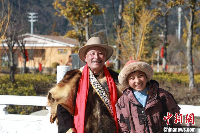 圖為林芝市巴宜區(qū)布久鄉(xiāng)仲果村村民桑杰與孫子一起參加藏歷新年活動(dòng)?！埩?攝