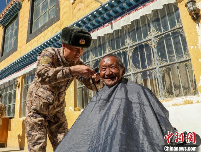 圖為阿里軍分區(qū)某邊防團(tuán)官兵為駐地群眾理發(fā)迎藏歷新年。　旦增倫珠 攝